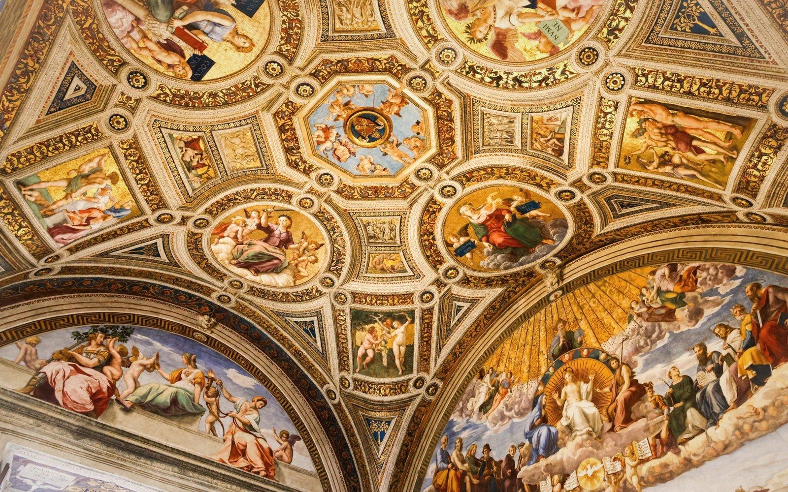 Gilded ceiling frescoes with ornate panels and figures in a domed gallery